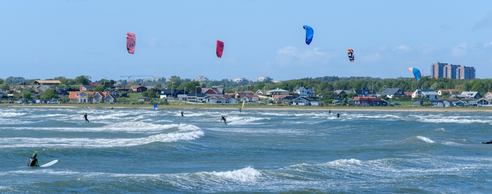Vindsurfare vid en strand.